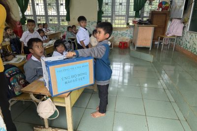 Các em học sinh Liên Đội Ama Jhao ủng hộ đồng bào lũ lụt.